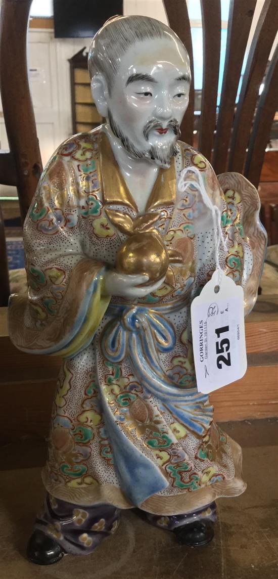 Early 20C Japanese porcelain figure of a man holding a peach